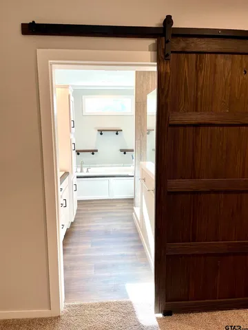 a view of a hallway with wooden floor and cabinet