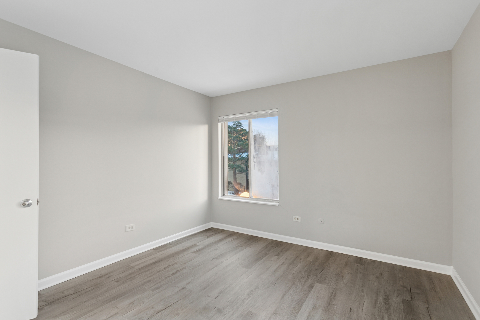 6185 Pinewood Court, Unit 202 Willowbrook, IL 60527 - Photo 12 of 20 a view of an empty room with wooden floor and a window