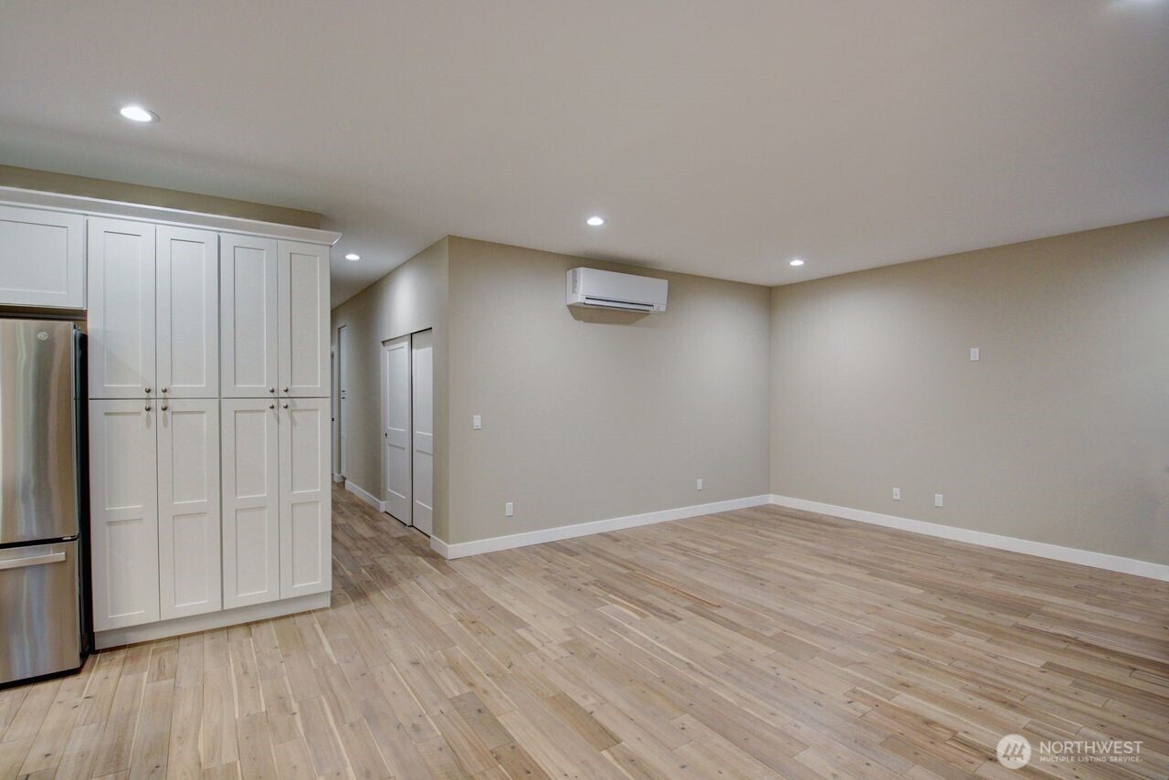8583 Trillium Lane Concrete, WA 98237 - Photo 18 of 34 a view of an empty room with wooden floor and a refrigerator