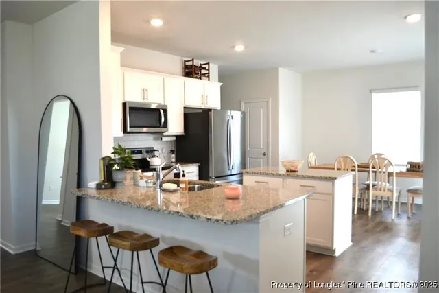 a kitchen with a table chairs and flat screen tv