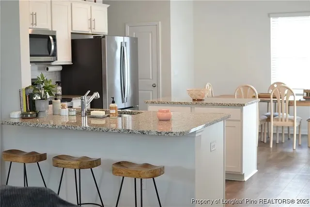 a kitchen with kitchen island granite countertop a table and chairs in it