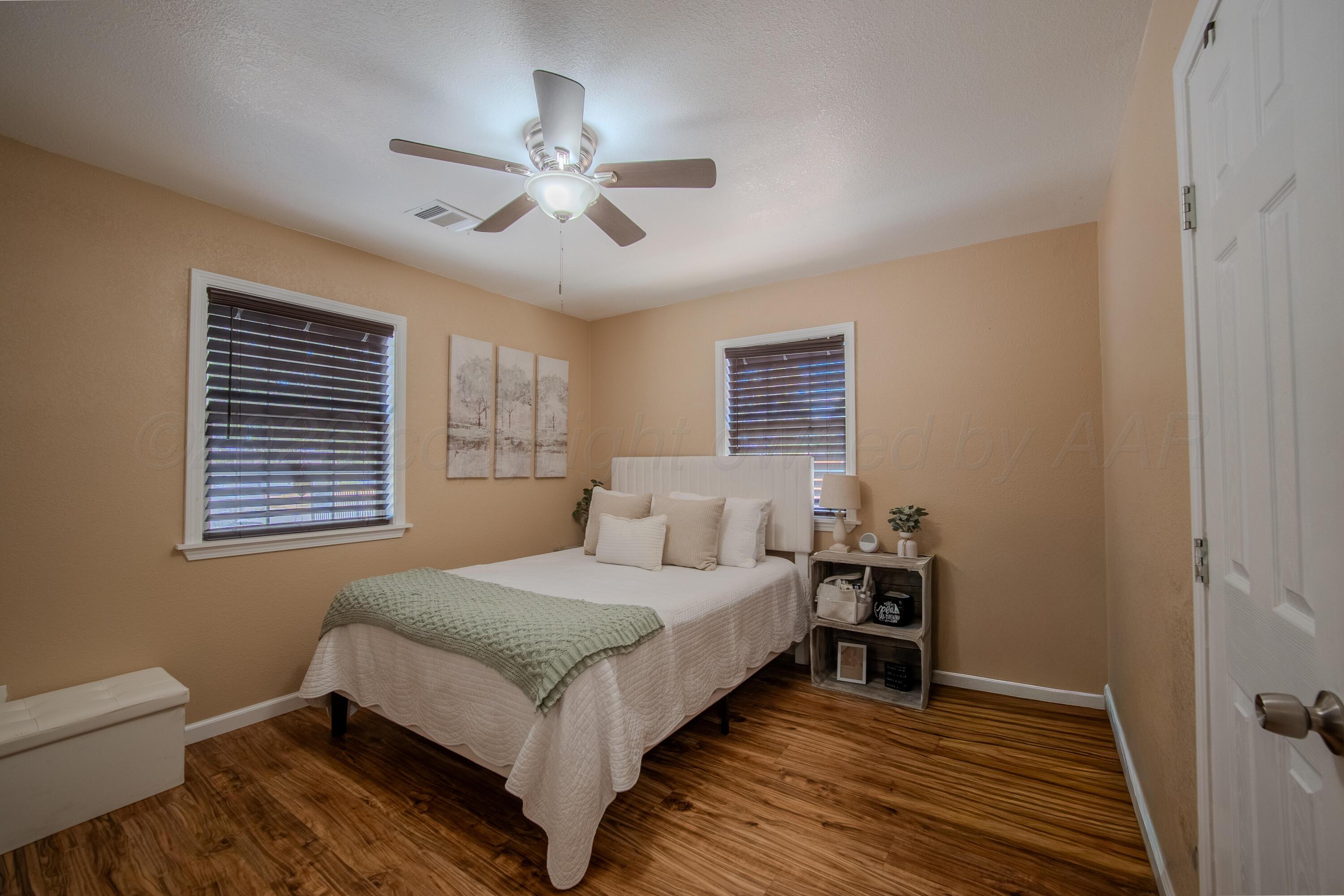 4014 Gables Street Amarillo, TX 79110 - Photo 6 of 14 a bedroom with a bed and a chandelier