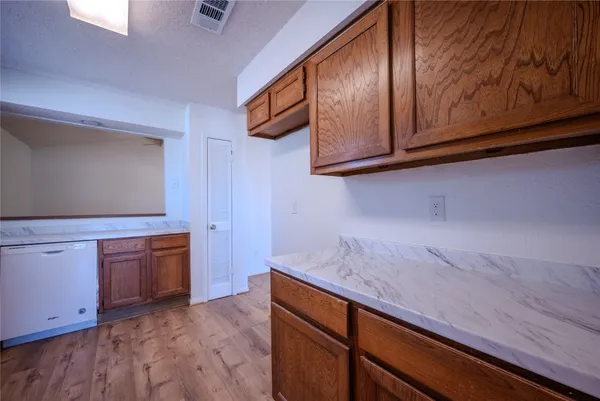 a kitchen with granite countertop white cabinets and stainless steel appliances