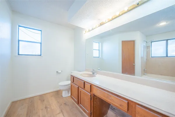 a bathroom with a sink a toilet and a window
