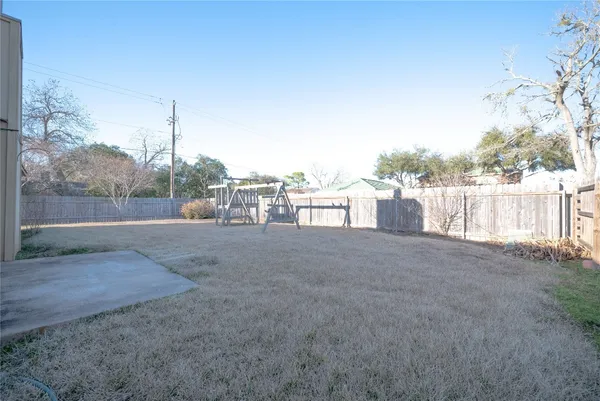 a view of a dry yard with wooden fence