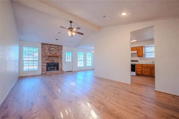 a view of a livingroom with a flat screen tv wooden floor and a fireplace