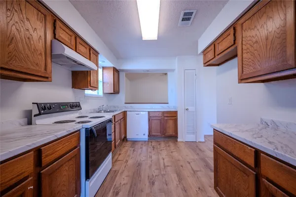 a kitchen with stainless steel appliances granite countertop wooden floors and sink