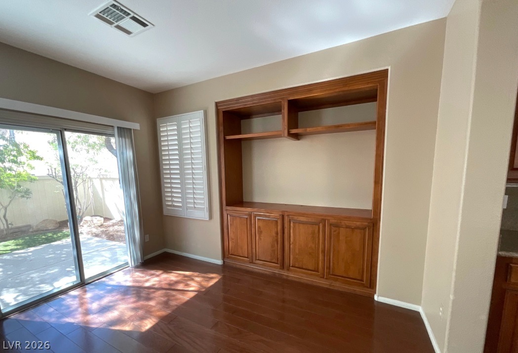 10841 Paradise Road Henderson, NV 89052 - Photo 5 of 35 Rich hardwood floors complement built-in cabinetry, with natural light pouring in from the private yard.