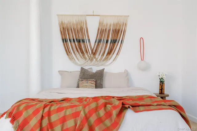 a bedroom with a bed and a painting on the wall