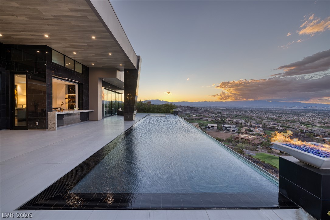 611 Cityview Ridge Drive Henderson, NV 89012 - Photo 61 of 66 An infinity pool blends into a vast desert valley panorama under a sunset sky.