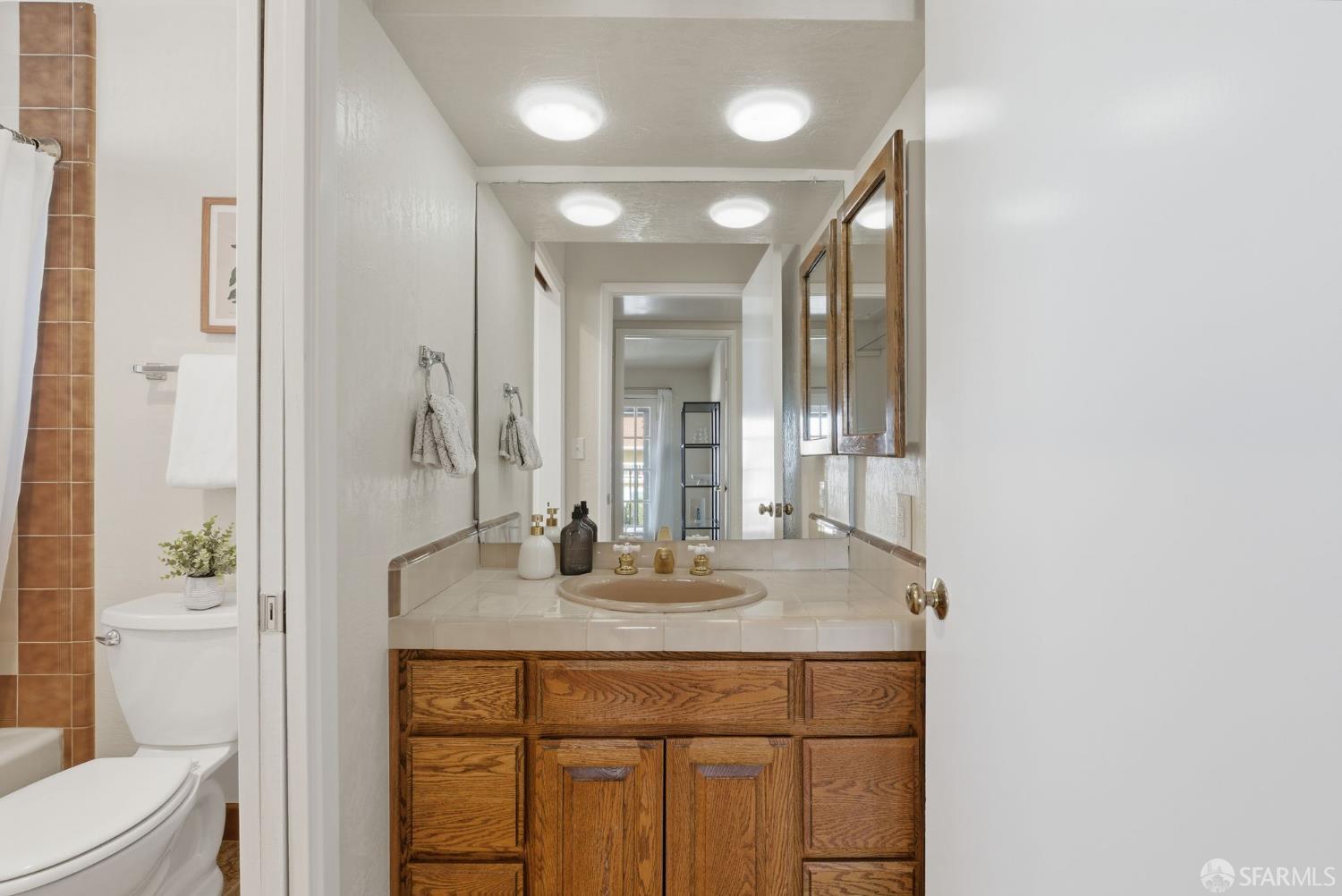 969 Springfield Drive Millbrae, CA 94030 - Photo 33 of 48 a bathroom with a granite countertop sink a toilet and a mirror