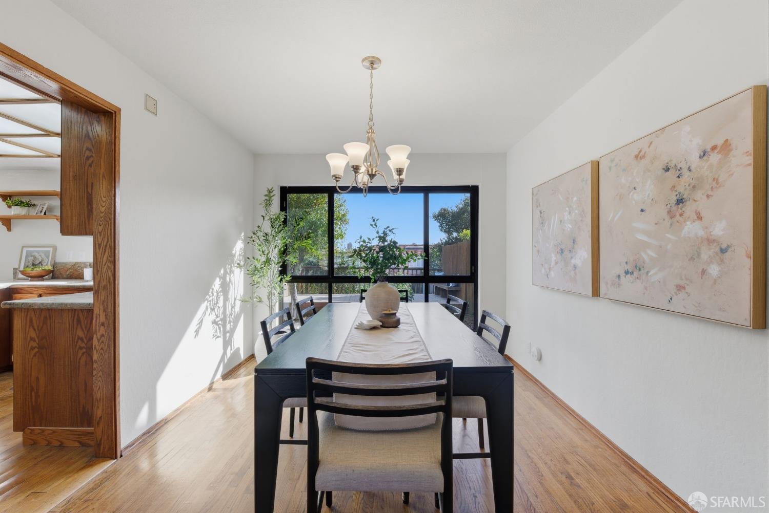 969 Springfield Drive Millbrae, CA 94030 - Photo 9 of 48 a dining room with wooden floor a chandelier a wooden table and chairs