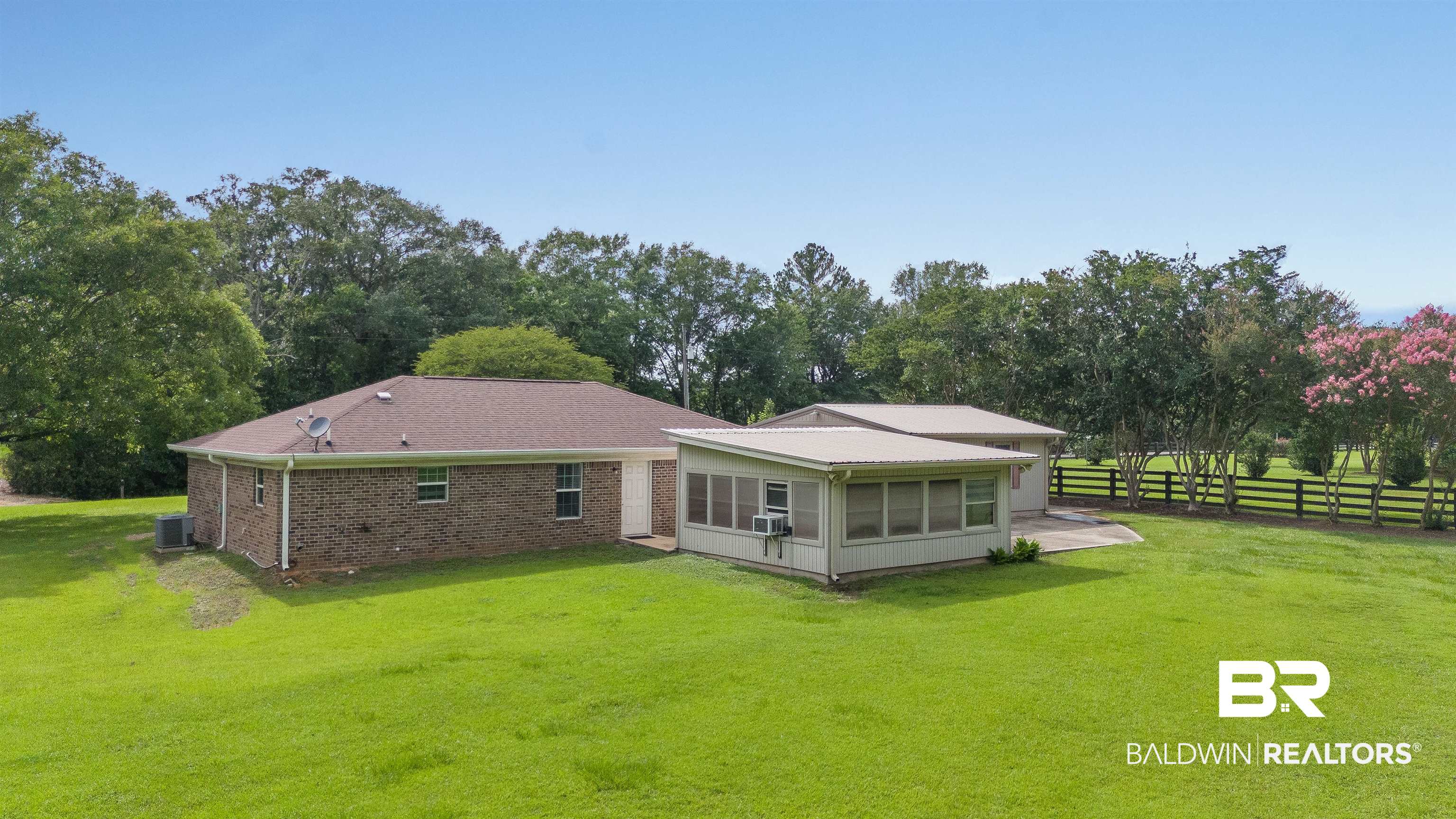 22810 Ard Road Robertsdale, AL 36567 - Photo 9 of 65 Back of house featuring a sunroom, view of wooded area, and brick siding