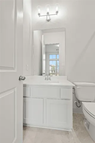 a bathroom with a sink vanity mirror and toilet