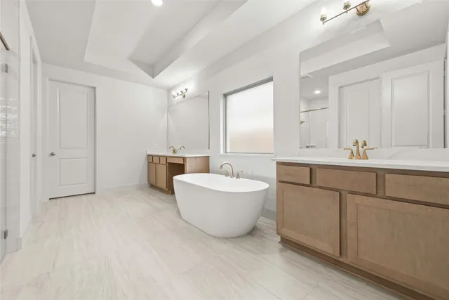 a bathroom with a double vanity sink mirror and bathtub