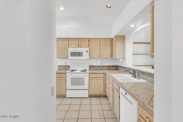 a kitchen with white cabinets and white appliances