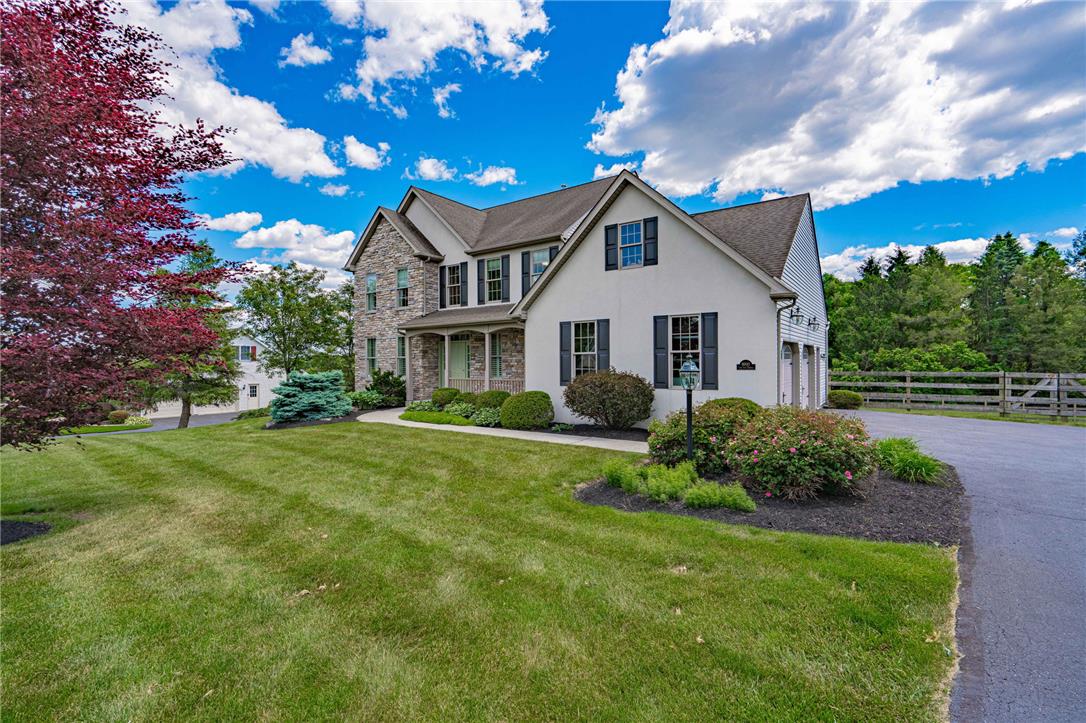 6000 Pond View Terrace Bath, PA 18014 - Photo 4 of 69 A classic facade combining stone and stucco greets visitors, framed by lush landscaping and a paved driveway.