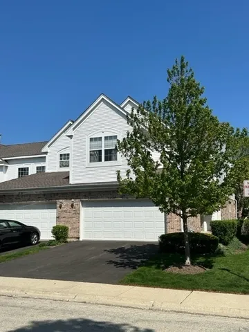 a front view of a house with garage and plants