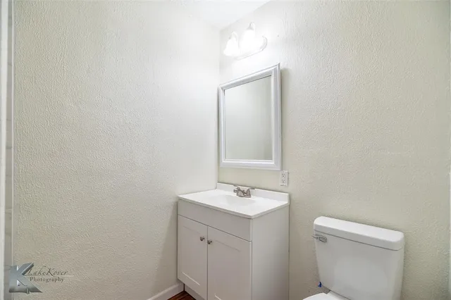 a bathroom with a toilet a sink a vanity and mirror