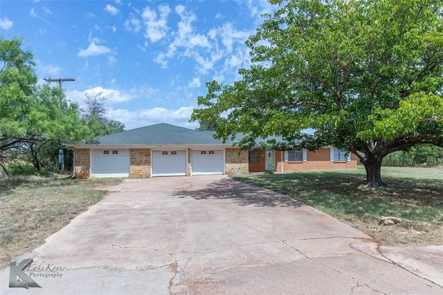 a view of a house with a tree in front of it