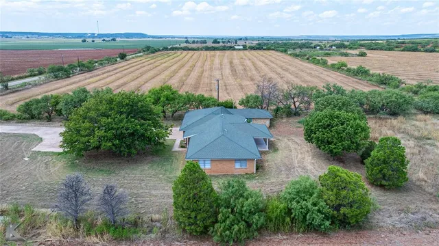 an aerial view of a house with a yard and lake view