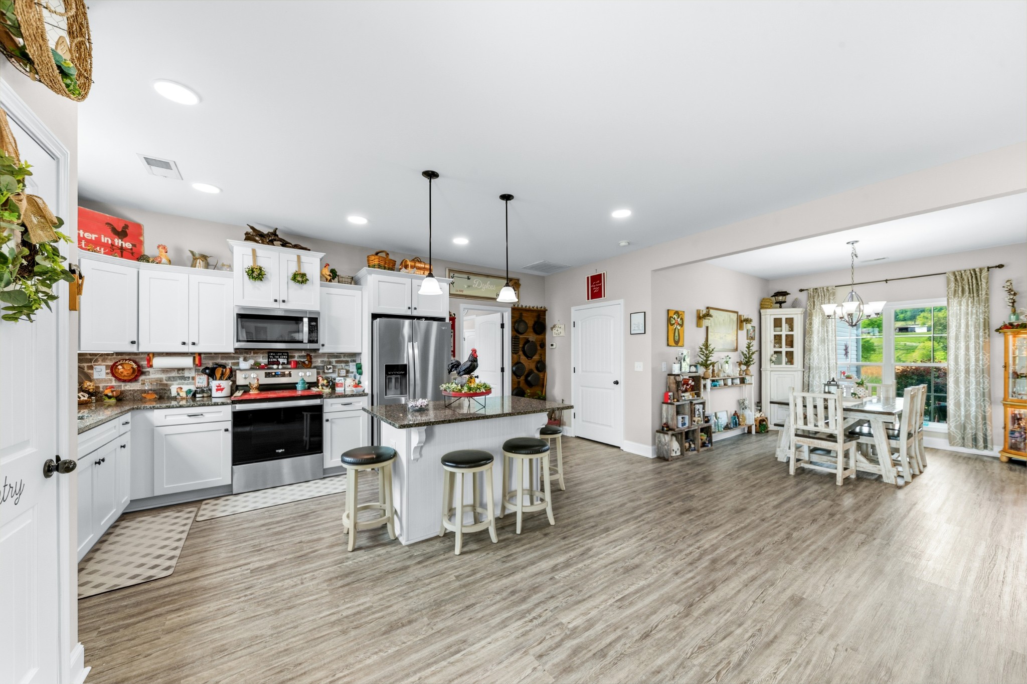 1224 Market Street Prospect, TN 38477 - Photo 17 of 80 a kitchen with stainless steel appliances a stove top oven a refrigerator a dining table and chairs with wooden floor