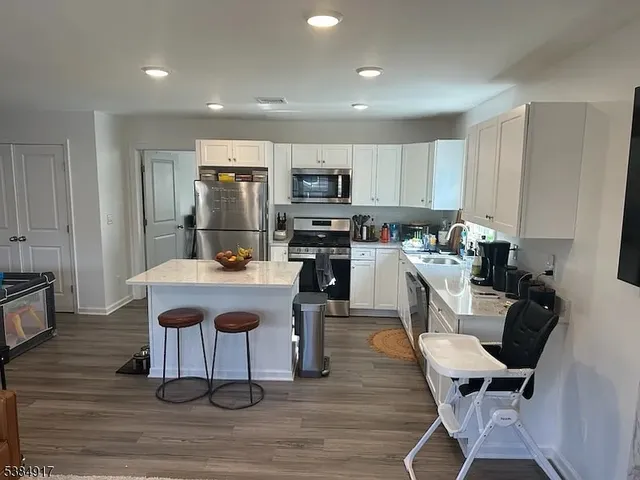 a kitchen with a sink cabinets and wooden floor