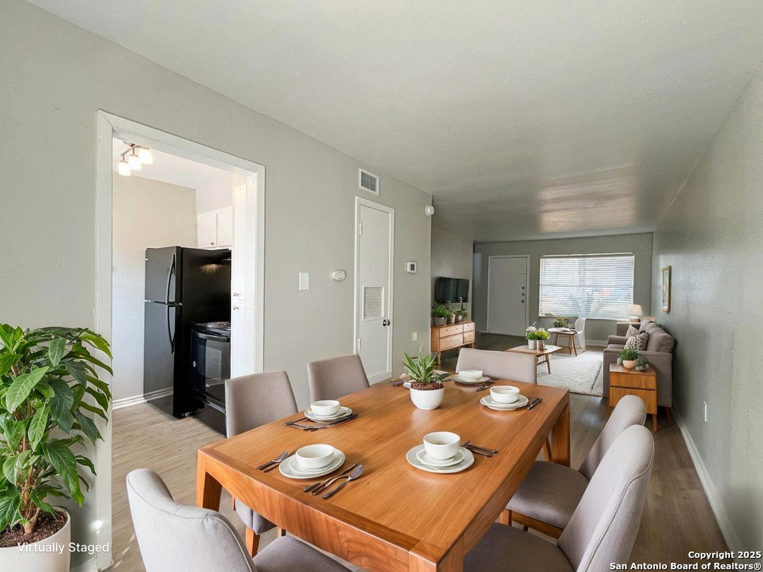 2802 Lasses Boulevard, Unit 8 San Antonio, TX 78223 - Photo 2 of 31 a dining room with furniture a wooden floor and a floor to ceiling window
