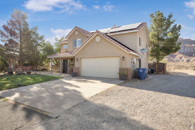 1440 West 100 South Virgin, UT 84779 - Photo 5 of 45 Two-story stucco residence featuring a covered entry porch, a two-car garage, and solar panels