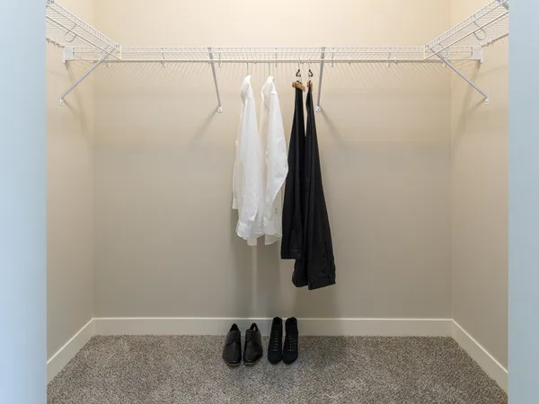 a view of walk in closet with clothes and shoes
