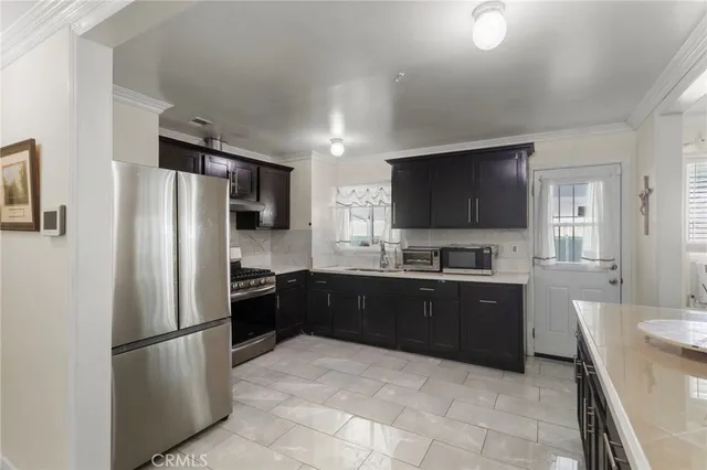 a large kitchen with a refrigerator and a stove top oven