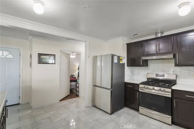 a kitchen with stainless steel appliances granite countertop a refrigerator and a stove