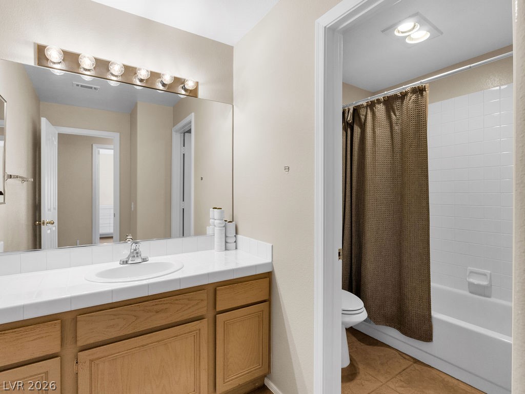 9201 Eagle Ridge Drive Las Vegas, NV 89134 - Photo 24 of 35 Bathroom with vanity, shower/bath combination with curtain, and light tile patterned flooring