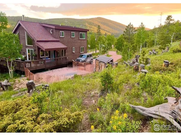 a view of a house with table and chairs under an umbrella