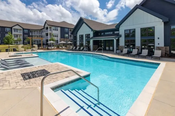 a view of a house with swimming pool and sitting area