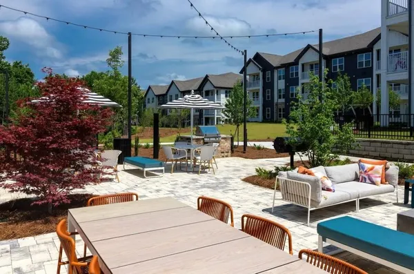 a outdoor space with patio fireplace couches and potted plants