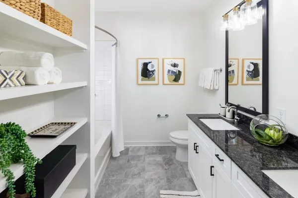 a spacious bathroom with a granite countertop sink and a mirror