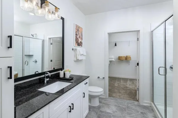a bathroom with a granite countertop sink toilet and shower