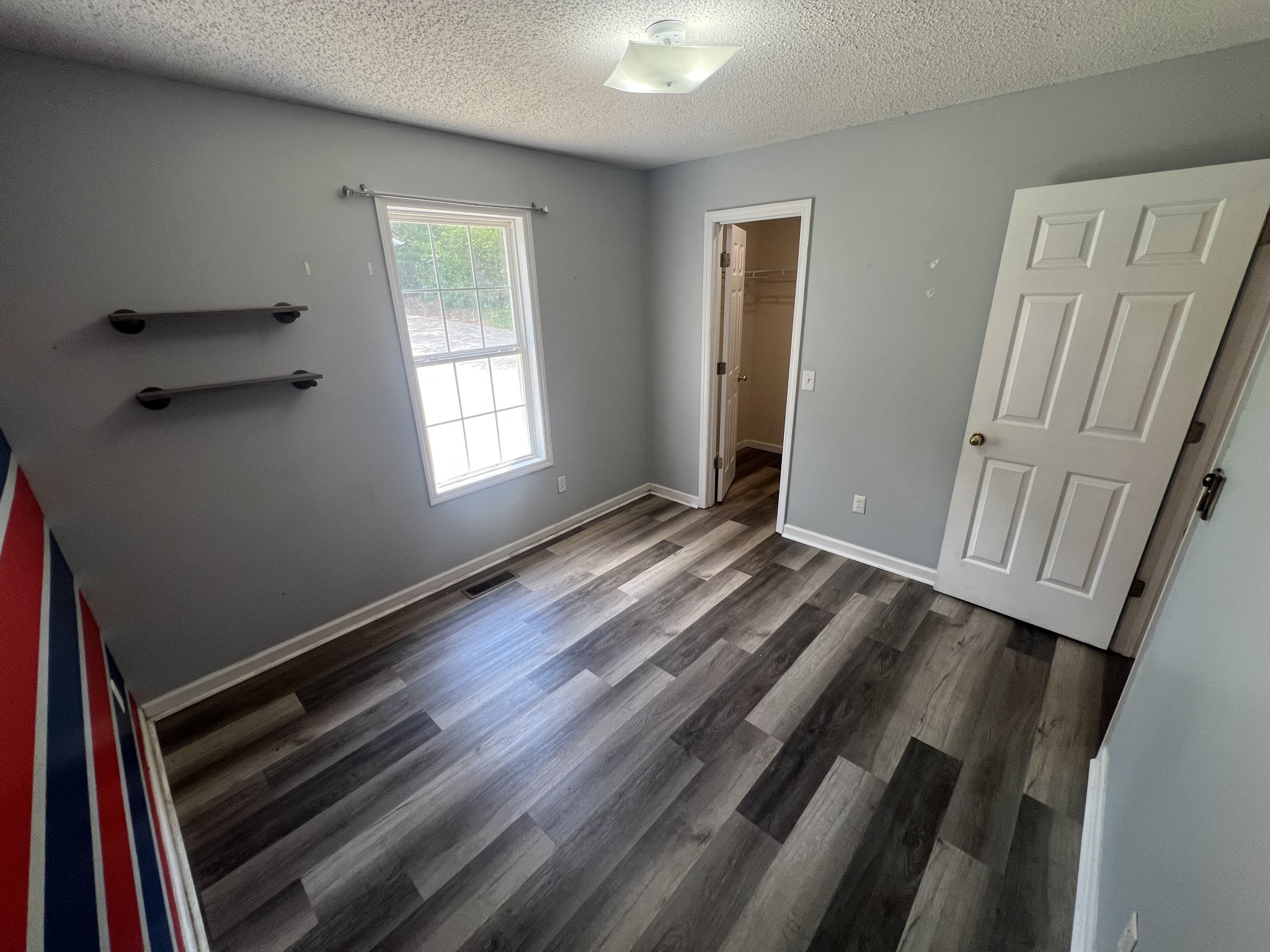 149 Hawthorne Street Pulaski, TN 38478 - Photo 20 of 33 a view of an empty room with wooden floor and a window