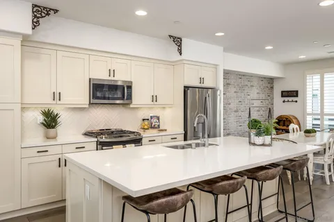 a kitchen with kitchen island a white cabinets and refrigerator