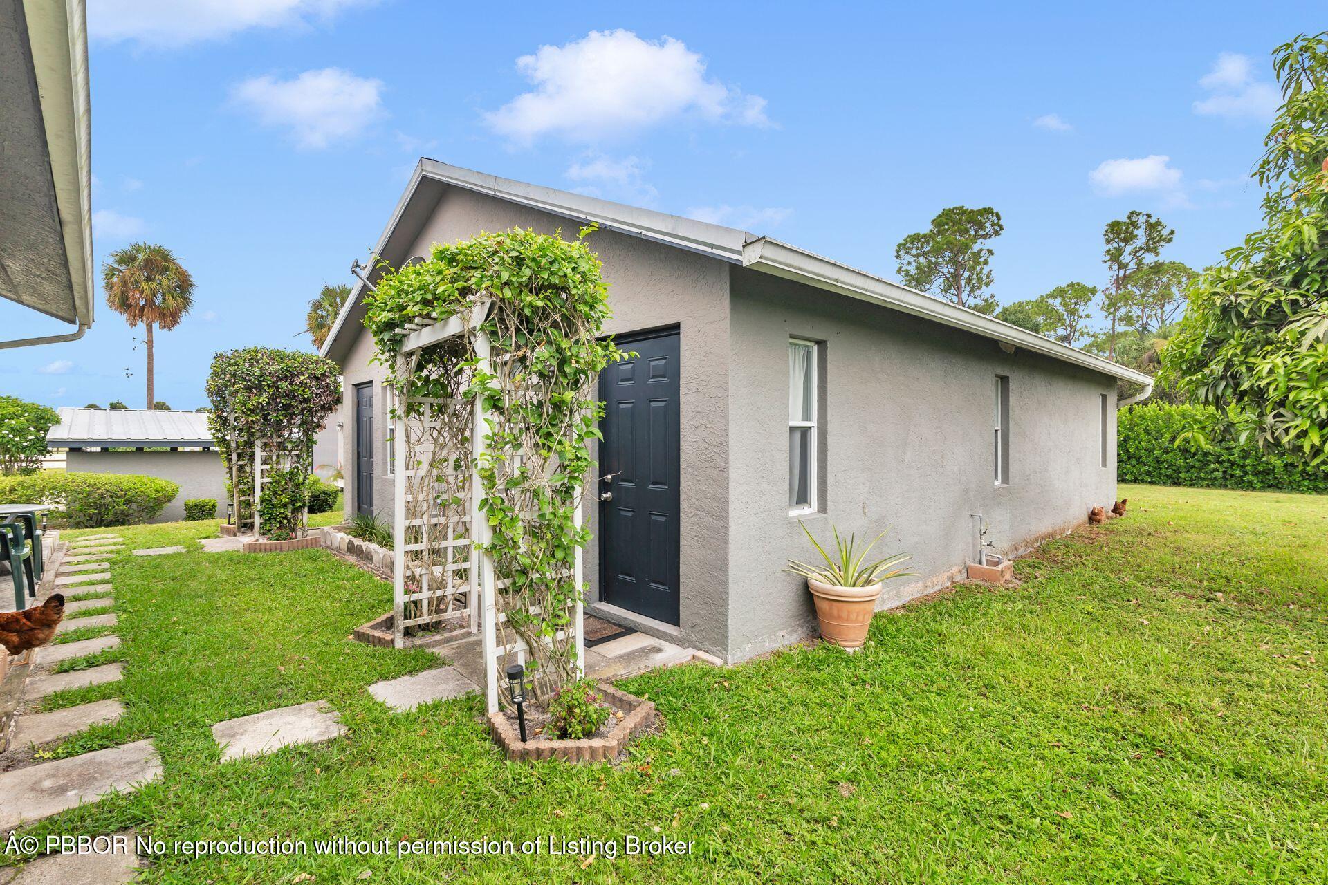 2770 E Road Loxahatchee, FL 33470 - Photo 35 of 51 a front view of a house with garden