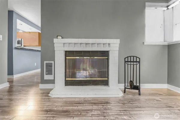 a view of a livingroom with wooden floor and a fireplace