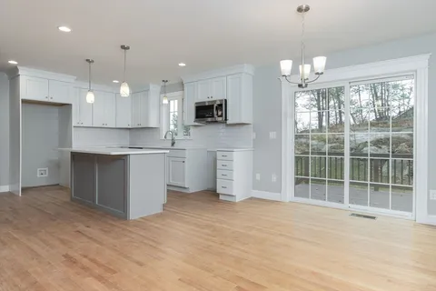 a view of a kitchen with kitchen island a sink stainless steel appliances and cabinets