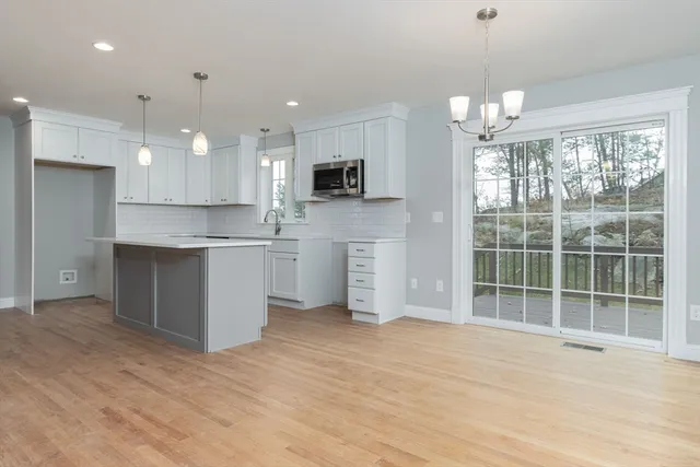 a view of a kitchen with kitchen island a sink stainless steel appliances and cabinets