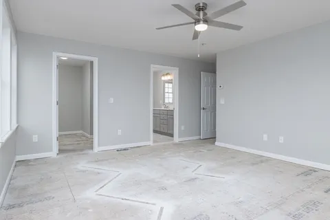 an empty room with closet and a ceiling fan