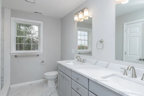 a bathroom with a toilet a sink and mirror