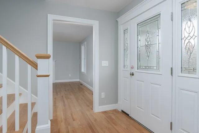 a view of a hallway with wooden floor and entryway