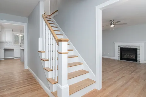a view of a hallway with wooden floor and staircase