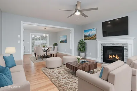 a living room with furniture a flat screen tv and a fireplace