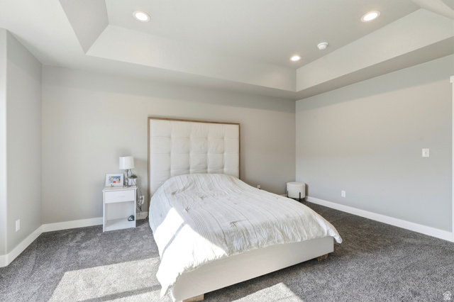 2216 South 1150 West Nibley, UT 84321 - Photo 19 of 34 Recessed lighting illuminates a room featuring a tray ceiling, light gray wall paint, white baseboards, and gray carpeting